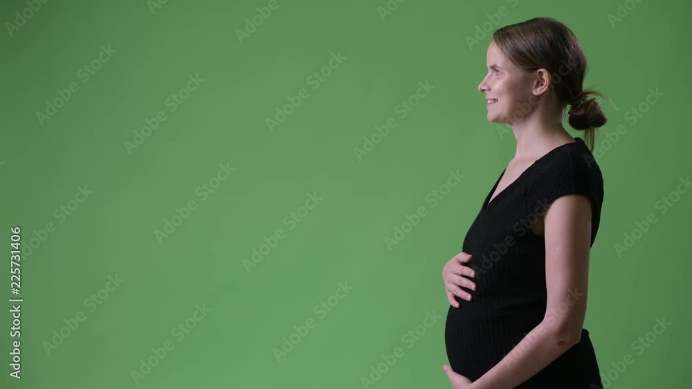 Profile view of young happy pregnant businesswoman Profile view of young happy pregnant businesswoman