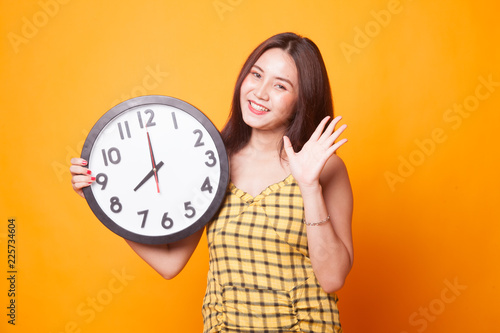 Happy Young Asian woman with a clock.