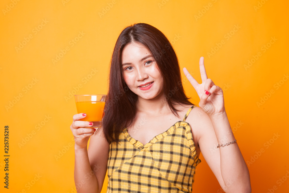 Young Asian woman show victory sign drink orange juice. - obrazy, fototapety, plakaty 