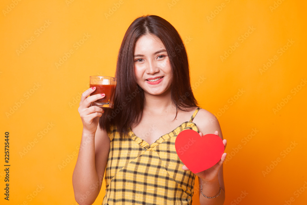 Young Asian woman with tomato juice and red heart. Young Asian woman with tomato juice and red heart.