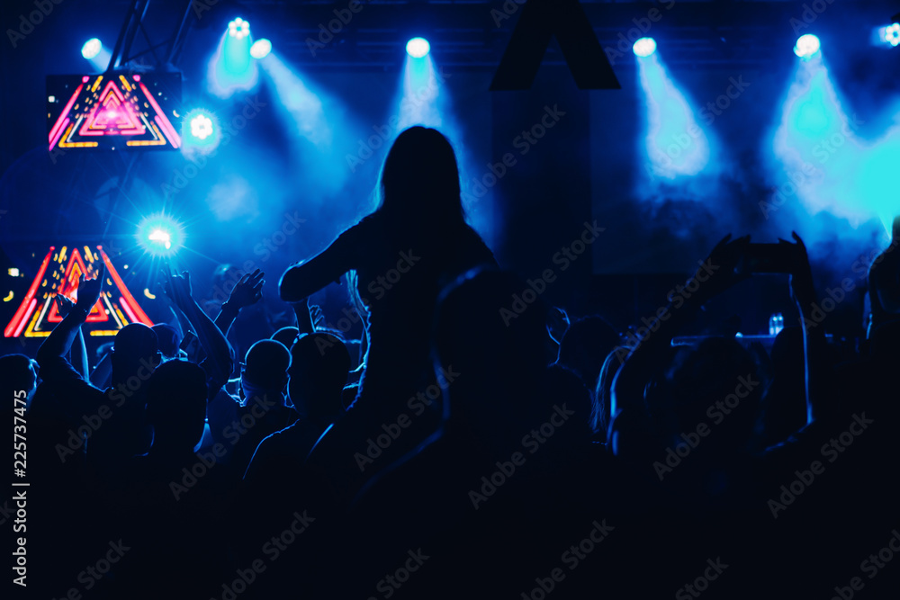 Silhouettes of concert crowd in front of bright stage lights Silhouettes of concert crowd in front of bright stage lights