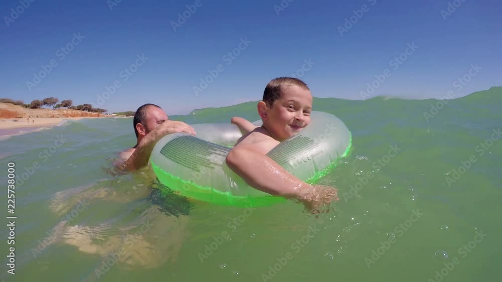 Children with the father and the inflatable circle, play bathed in the sea. Children with the father and the inflatable circle, play bathed in the sea.