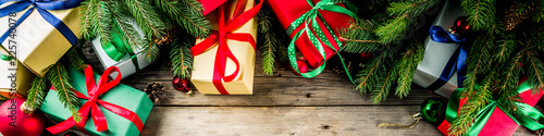 Christmas festive background with decorations and colorful gift boxes on wooden board banner