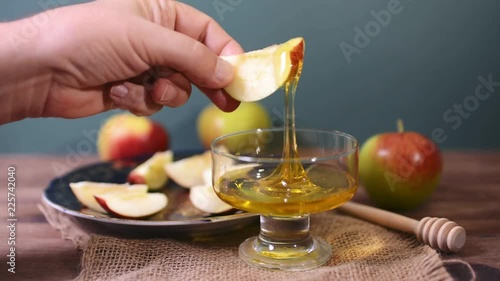 man dipping an apple in honey