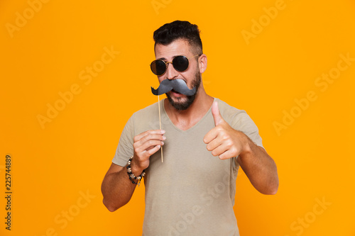 Portrait of a cheerful young casual man in sunglasses photo