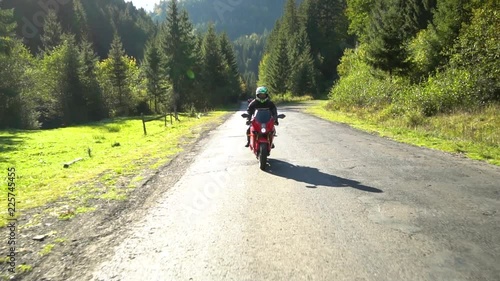 A guy on a motorcycle. Young handsome guy rides a motorcycle on a mountain road.