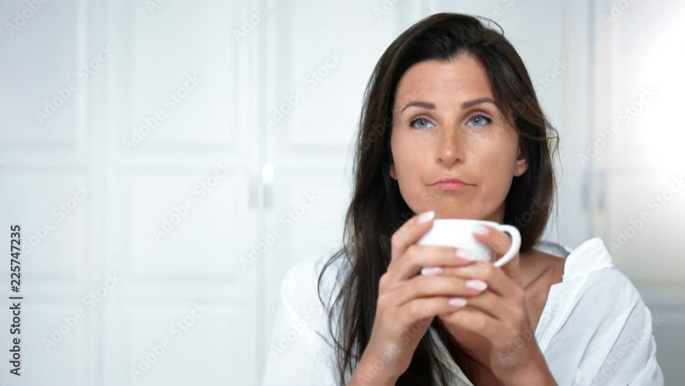 Portrait friendly pensive woman drinking tea or coffee enjoying morning at home or hotel interior Portrait friendly pensive woman drinking tea or coffee enjoying morning at home or hotel interior