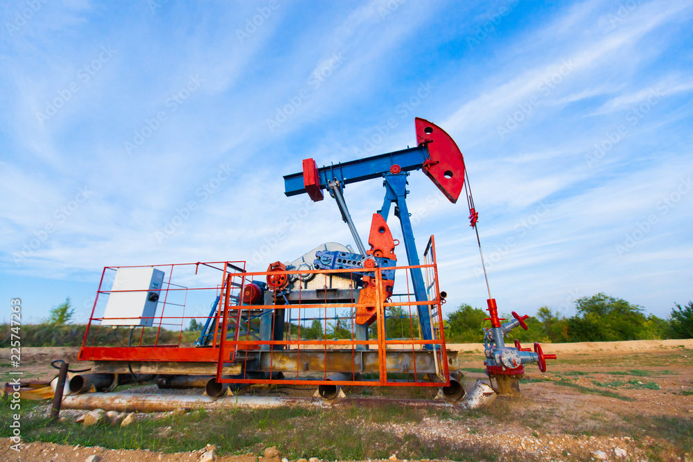 The oil pump, industrial equipment. Oil field site, oil pumps are running. Rocking machines for oil production in a private sector. The oil pump, industrial equipment. Oil field site, oil pumps are running. Rocking machines for oil production in a private sector.