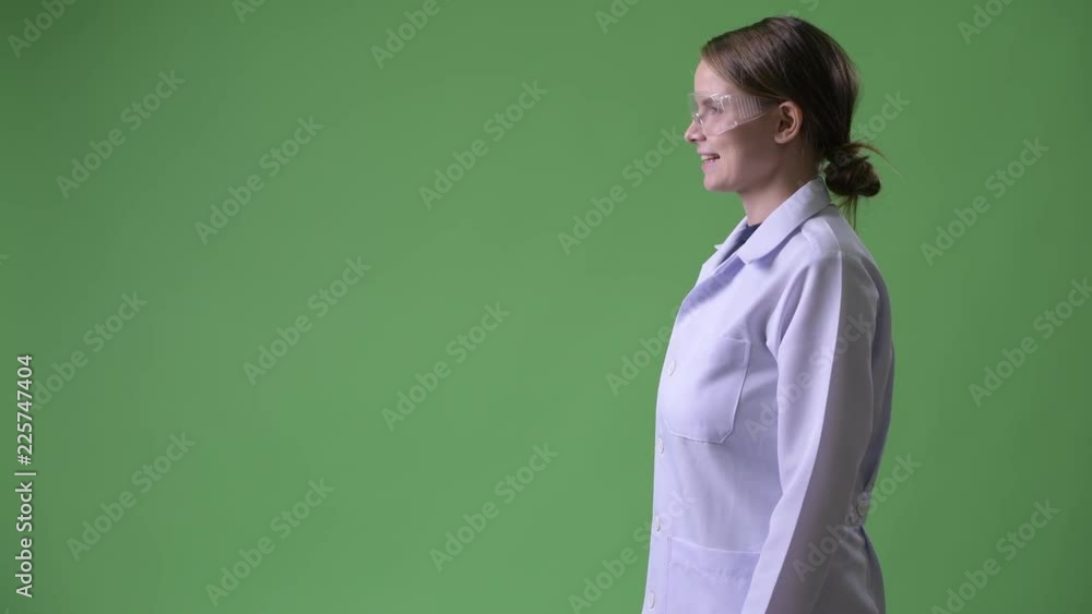 Profile view of young happy woman doctor wearing protective glasses Profile view of young happy woman doctor wearing protective glasses
