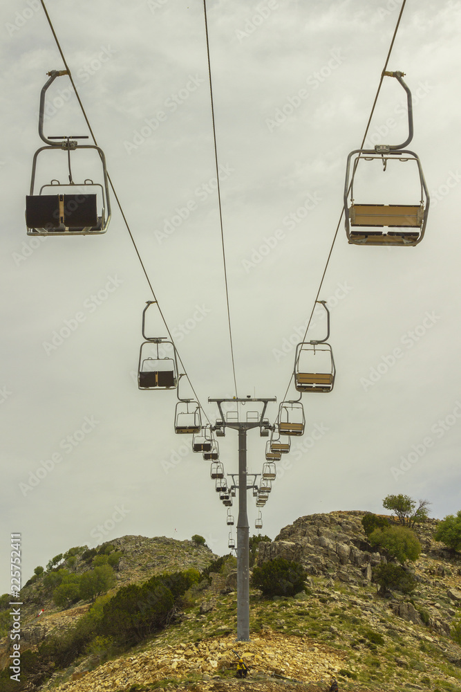 empty chair lift on the mountainside in summer. empty chair lift on the mountainside in summer.