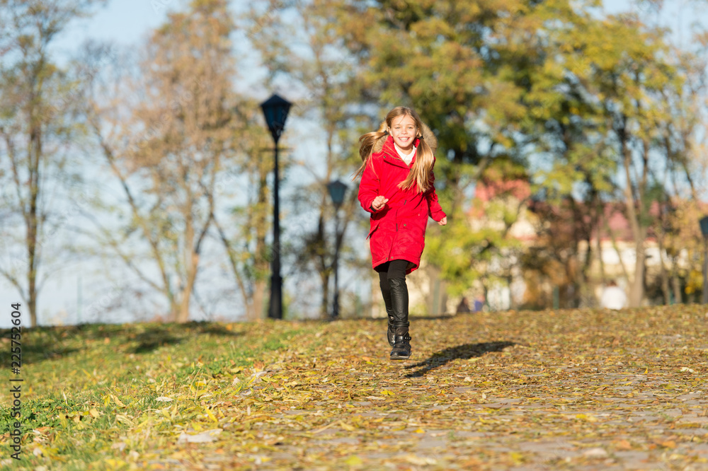 Fall clothes and fashion concept. Child blonde long hair walking fall park background. Feel cozy in warm jacket. Girl happy wear coat with hood enjoy fall nature. Child wear coat for fall season Fall clothes and fashion concept. Child blonde long hair walking fall park background. Feel cozy in warm jacket. Girl happy wear coat with hood enjoy fall nature. Child wear coat for fall season
