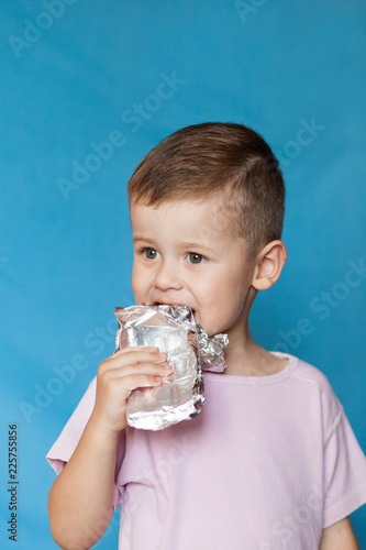 Cute Little Boy Eating Chocolate Bar. Very cute kid with chocolate, isolated.