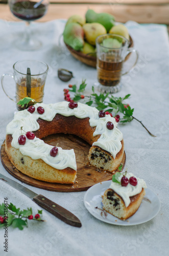 Bundt cake with cinnamon covered with white glaze on rustic background with autumn decorations photo