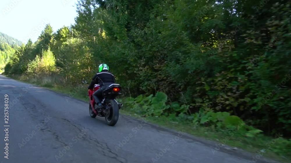 A guy on a motorcycle. Young handsome guy rides a motorcycle on a mountain road. A guy on a motorcycle. Young handsome guy rides a motorcycle on a mountain road.