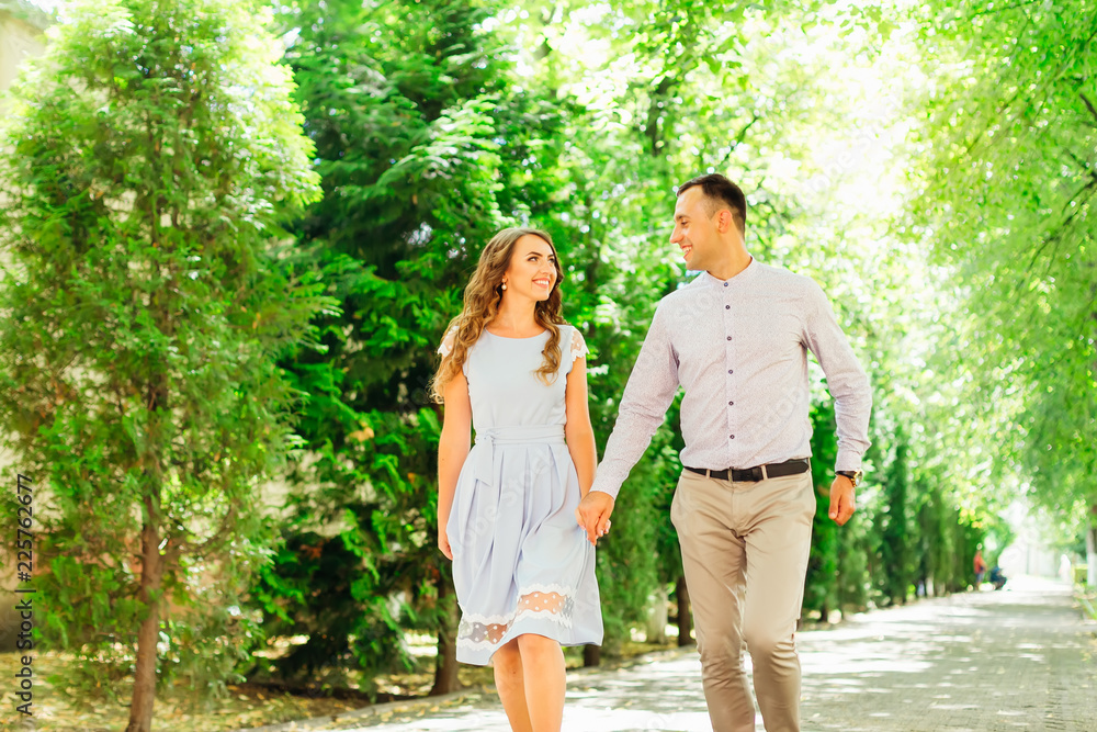 a cute walk of two lovers who hold hands and smile genuinely a cute walk of two lovers who hold hands and smile genuinely