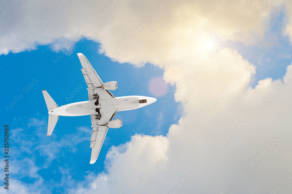 Obraz premium Airplane flies high in the sky, a journey through the clouds sun light glare.