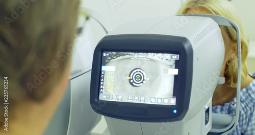 Woman doctor working with the refractometer machine. Close-up of ophthalmology technology