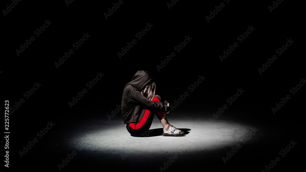 Depressed teenager girl sit on the floor hugging her knees Stock Photo ...