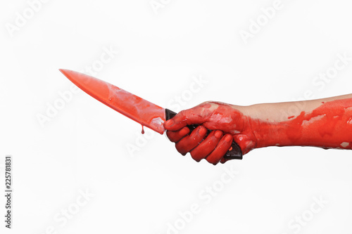 Closeup shot of hand holding a bloody knife with blood dripping.