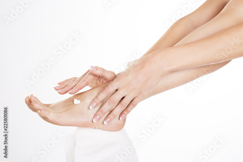 Female feet leg cream on white background isolation. © Stavros