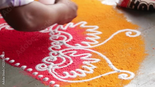 Rangoli with coloured powder being created by Rangoli artist on occasion of Hindu festival, Mumbai, Maharashtra, India.