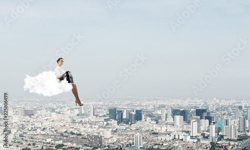 Businesswoman or accountant on cloud floating high above modern city