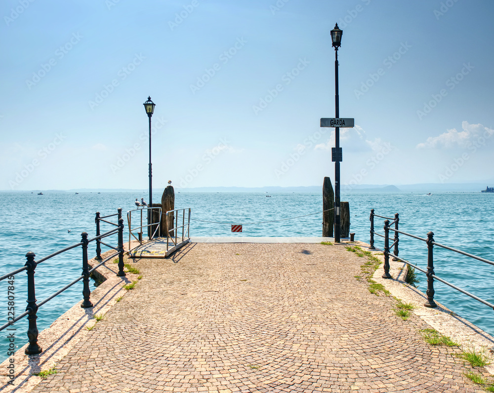 Veiw to the Garda lake from pier, summer in Italy.