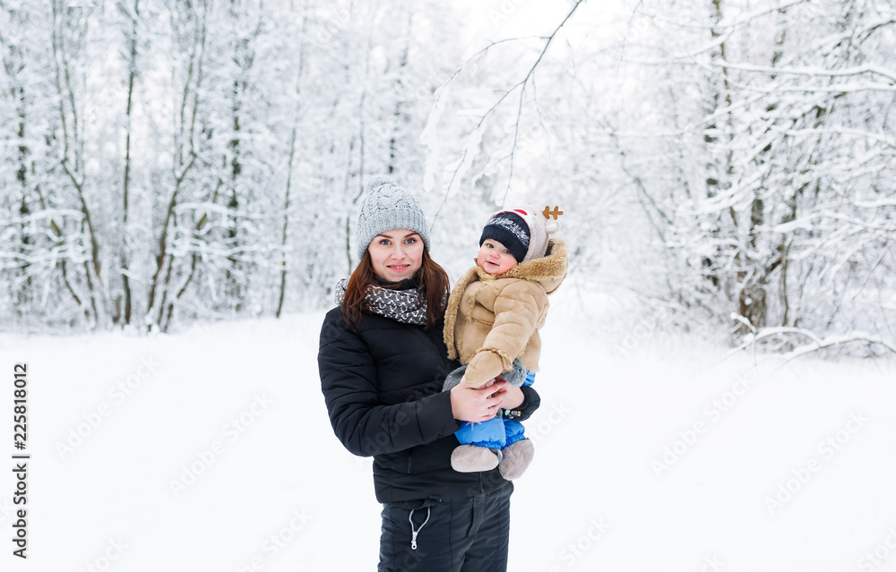 A young mother holds her baby son in her arms.