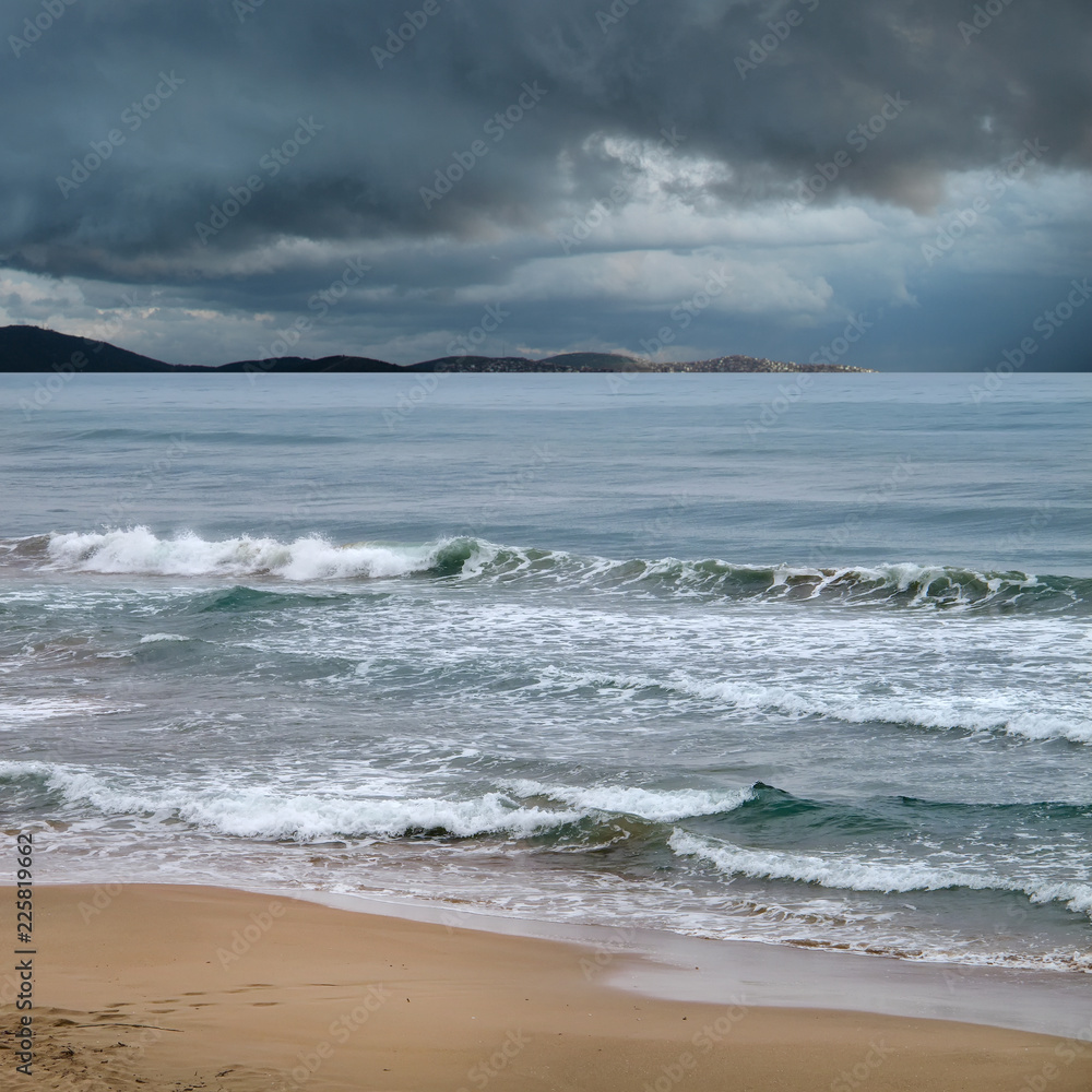 Seascape of sandy beach with waves in stormy day Seascape of sandy beach with waves in stormy day