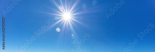 sky background with sun beams on bright blue sky