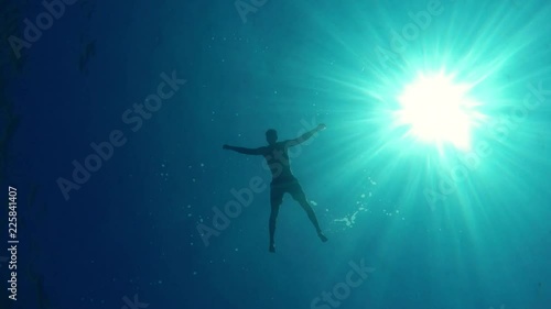 Man floating on water, bottom of the sea POV
