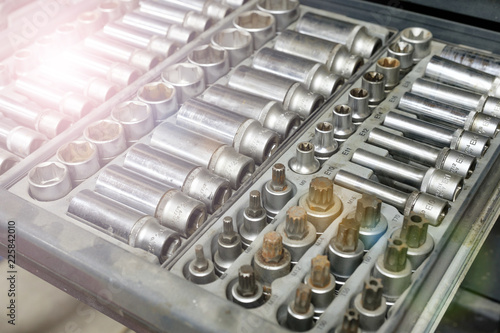 Set of tools closeup - wrench heads, nozzles the screwdriver in case. Professional instrument. Selective focus.