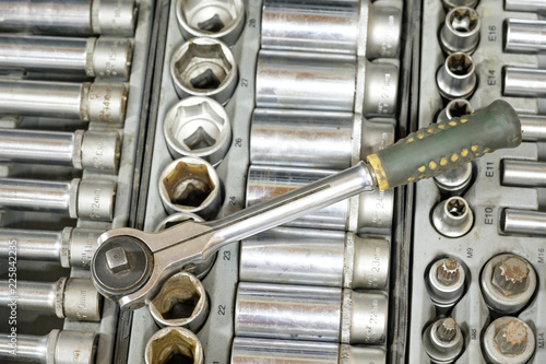 Set of tools closeup - wrench heads, nozzles the screwdriver in case. Professional instrument. Selective focus.