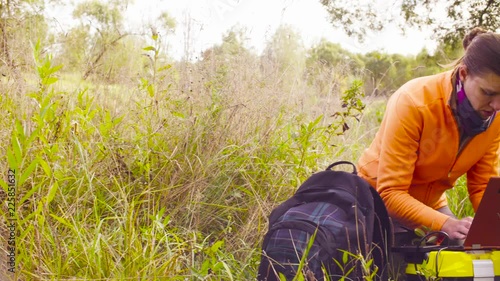 Crane shot. Woman scientist ecologist working on a laptop in the forest