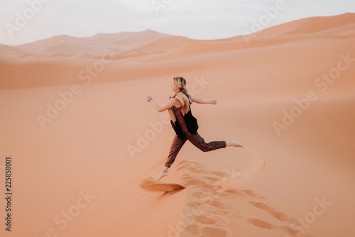 Woman running in desert, Douba, Morocco photo