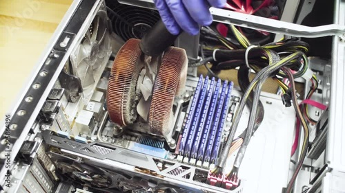 Crane shot. Close up repairing of computer. Cleaning computer system unit from dust with a vacuum cleaner