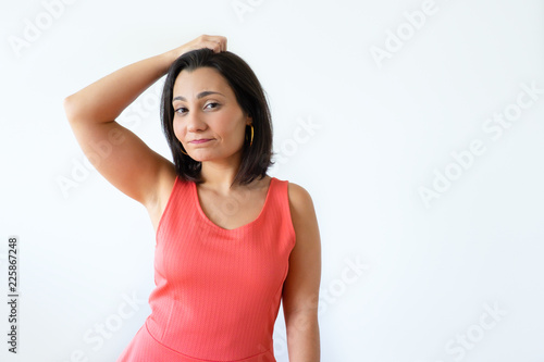 Beautiful confused Indian woman touching head and thinking. Attractive girl in pink clothes holding head and looking at camera. Isolated on white. Thinking concept photo