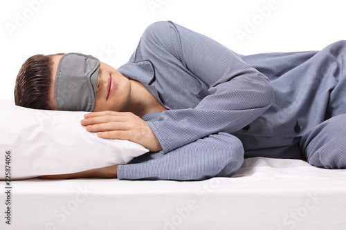 Young male sleeping on a pillow with eye mask photo