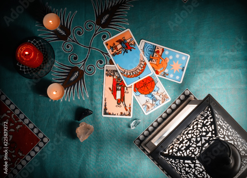 Fortune-telling on traditional tarot cards on a blue tablecloth with a lantern and candles. photo