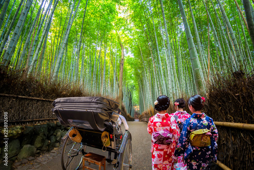 Young women wearing traditional Japanese Kimono and Rickshaw for sightseeing at Bamboo forest of Arashiyama,  Arashiyama is a district on the western outskirts of Kyoto, Japan.