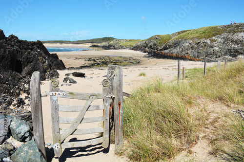 A gate leading onto the shore from Llanddwyn Island on the coast of Anglesey in North Wales