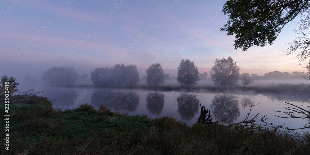 Spiegelung einer Baumreihe an einem See vor dem Sonnenaufgang Spiegelung einer Baumreihe an einem See vor dem Sonnenaufgang