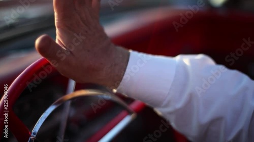 A Man's Hand Drummed On The Steering Wheel Of The Red Vintage Car.