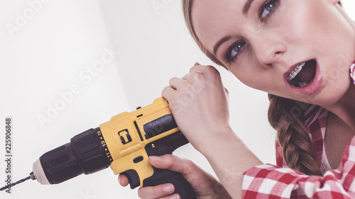 Woman having troubles using drill