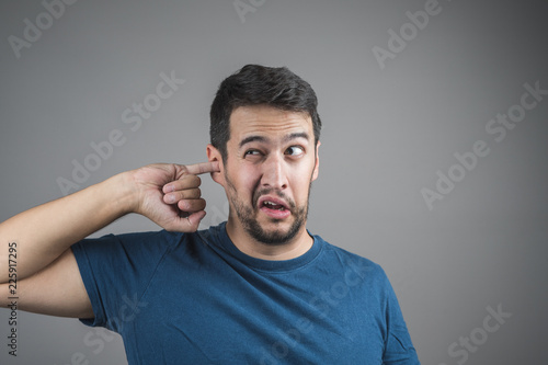 young man picking his ear with his finger