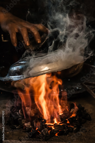 Traditional Turkish Tinsmith Covering the Copper Plate With Tin Over Fire photo