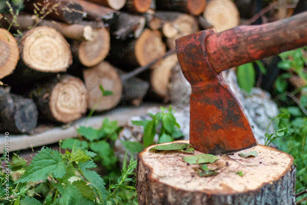 The ax near the woodpile stuck in the stump The ax near the woodpile stuck in the stump
