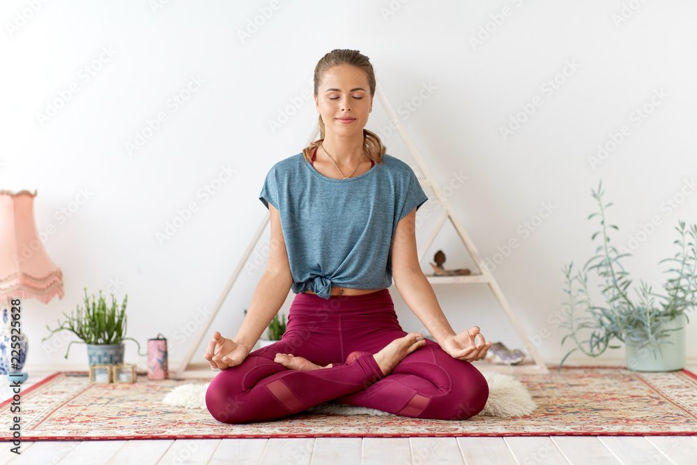 mindfulness, spirituality and healthy lifestyle concept - woman meditating in lotus pose at yoga studio - obrazy, fototapety, plakaty 