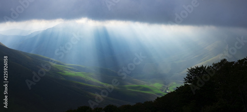Sun rays seep through the clouds in the Pyrenees of France
