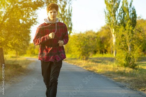 young teenager run in the early morning in countryside road beween the green meadows f photo